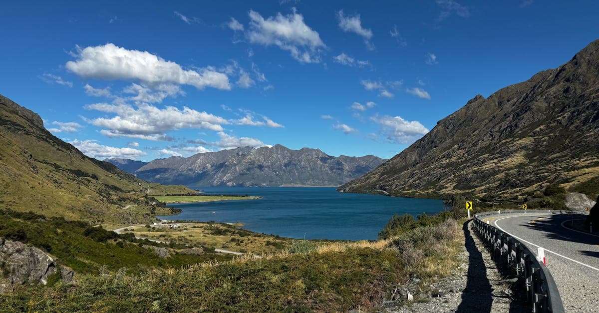 Pristine Lake Hawea framed by rugged mountains under a clear sky, illustrating New Zealand trip scenery and costs.
