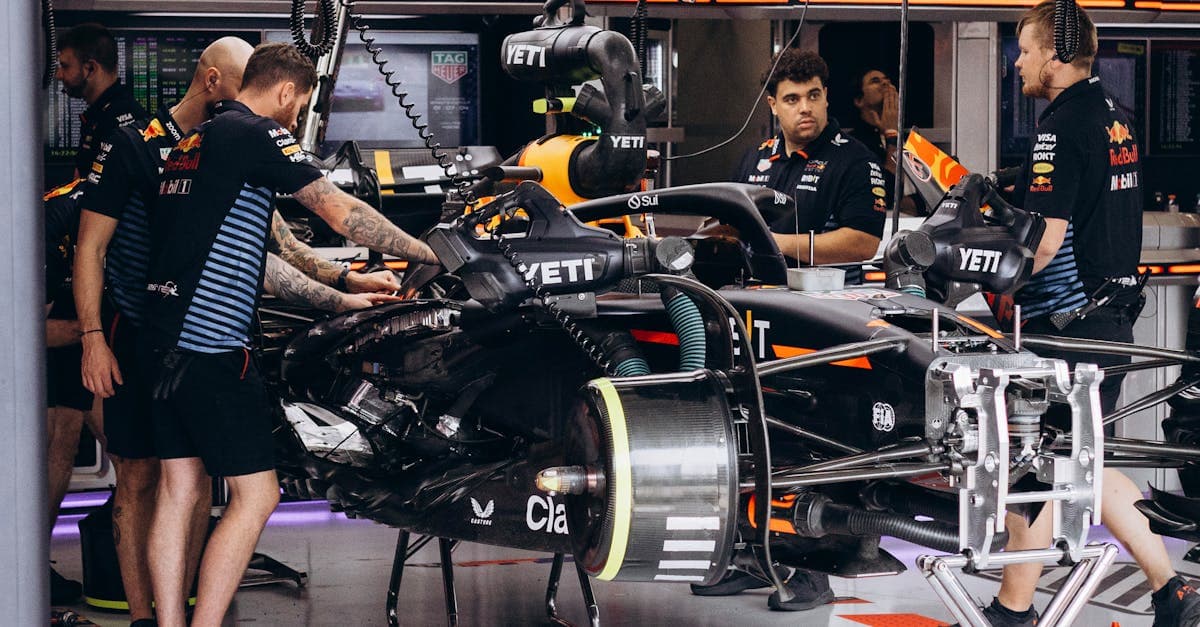 Meccanici al lavoro sulla monoposto in corsia box, preparando la vettura per la nuova griglia f1 2026.