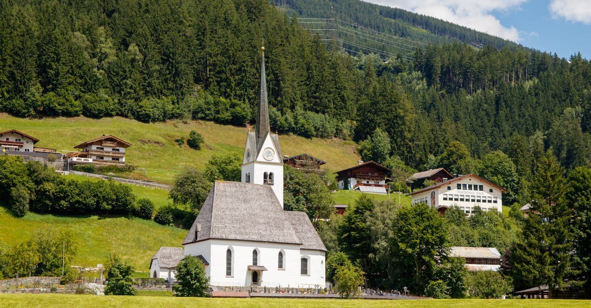 Malerisches Tiroler Alpendorf mit historischer Kirche und grünen Hügeln als Kulisse für das Gauderfest 2026.