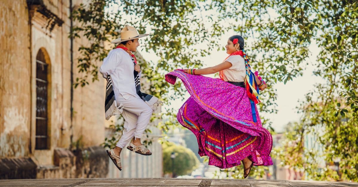 Traditional folk dancers in colorful costumes celebrating cultural heritage in Oaxaca Mexico.
