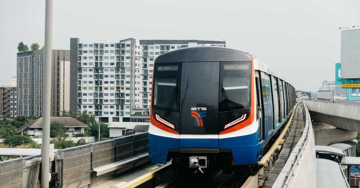 BTS Skytrain i Bangkok glider fram på upphöjda spår mot en imponerande stadssilhuett.