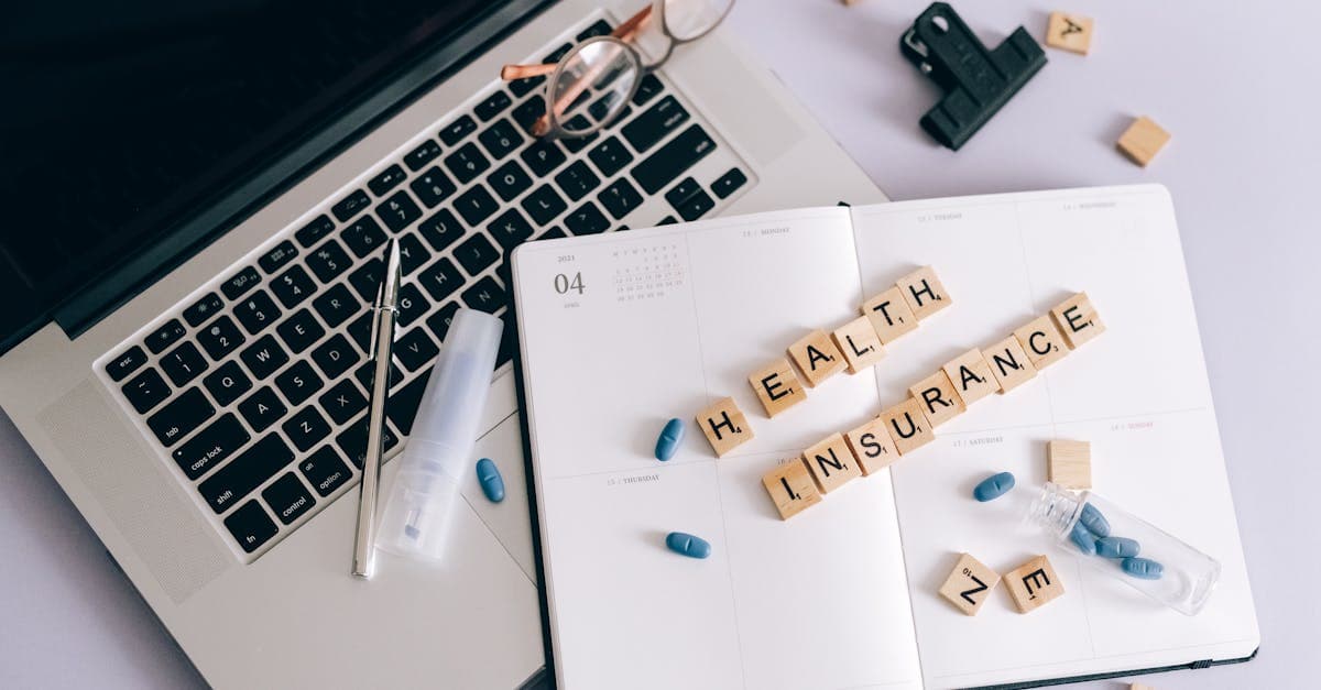 Laptop, notebook, and pills arranged together, illustrating how pre-existing conditions affect travel insurance premiums.