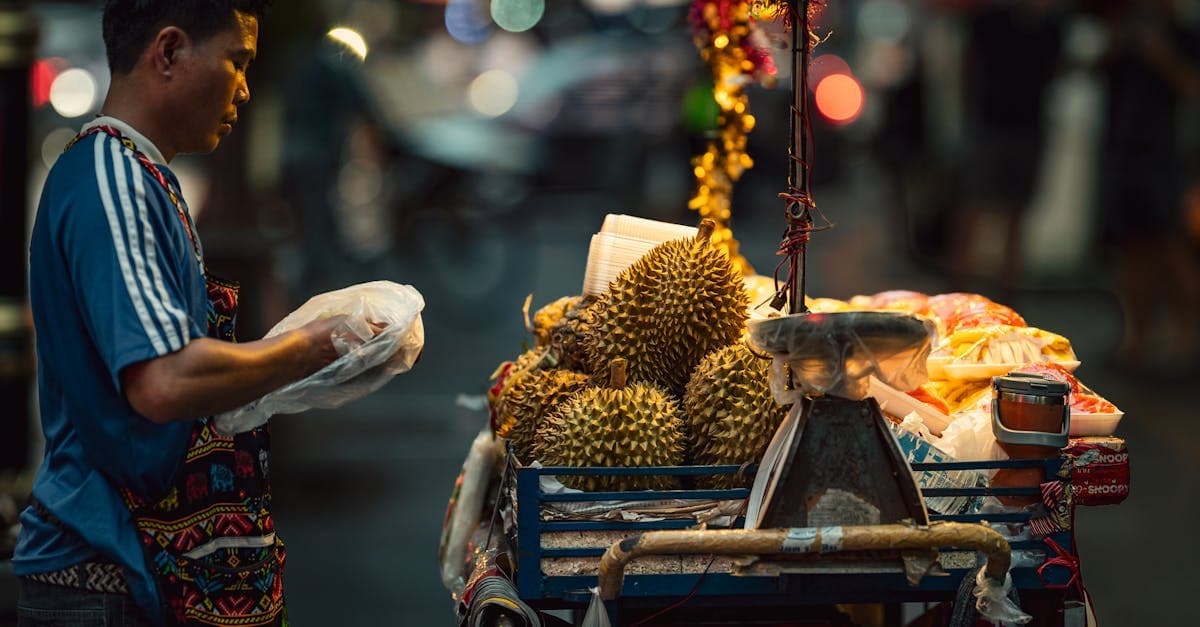 Durian vendor at Bangkok's vibrant night market, a perfect stop while exploring food streets with a travel eSIM