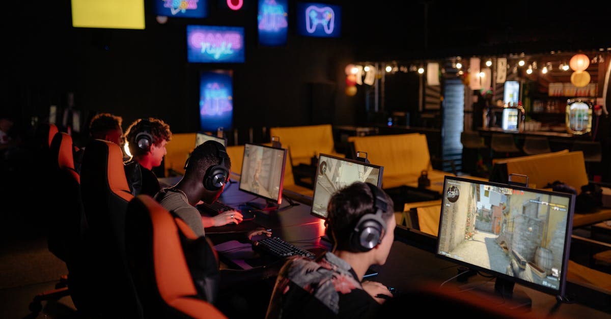 Gamers competing in an online tournament at a modern internet cafe, screens illuminated.