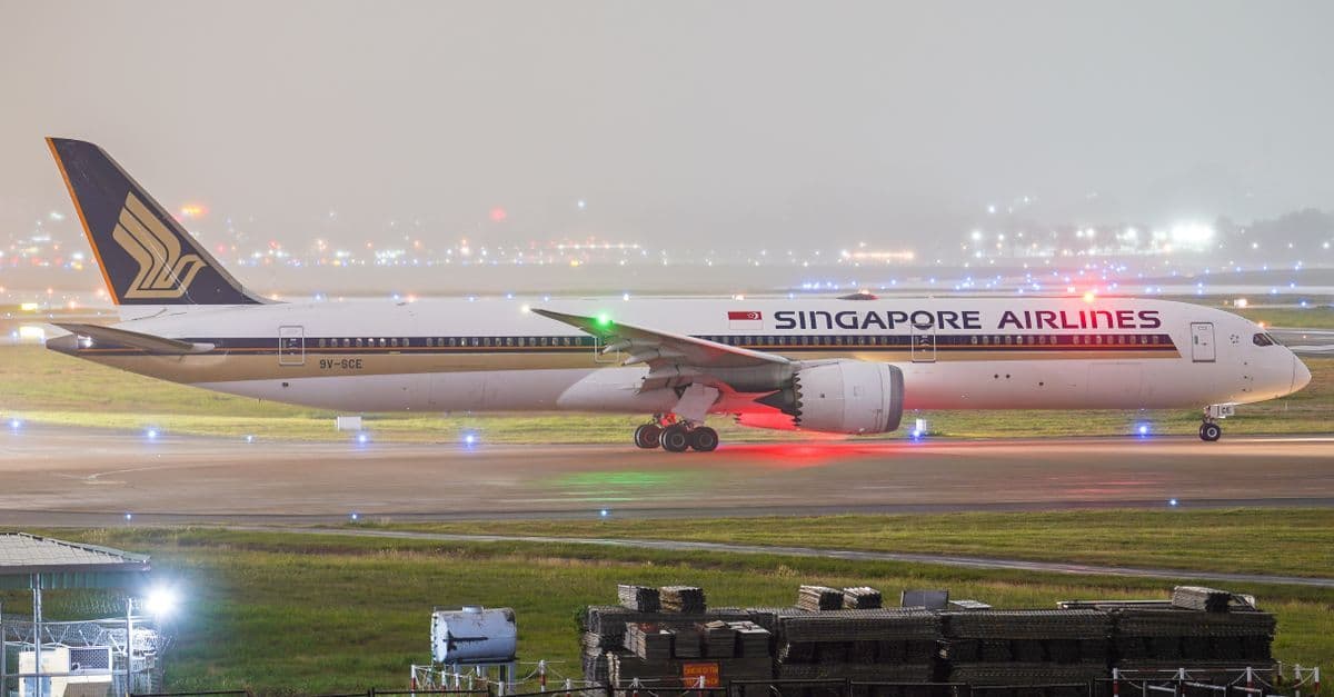 Singapore Airlines Boeing 787 Dreamliner taxiing on a runway at night ahead of a Sydney to Singapore flight.