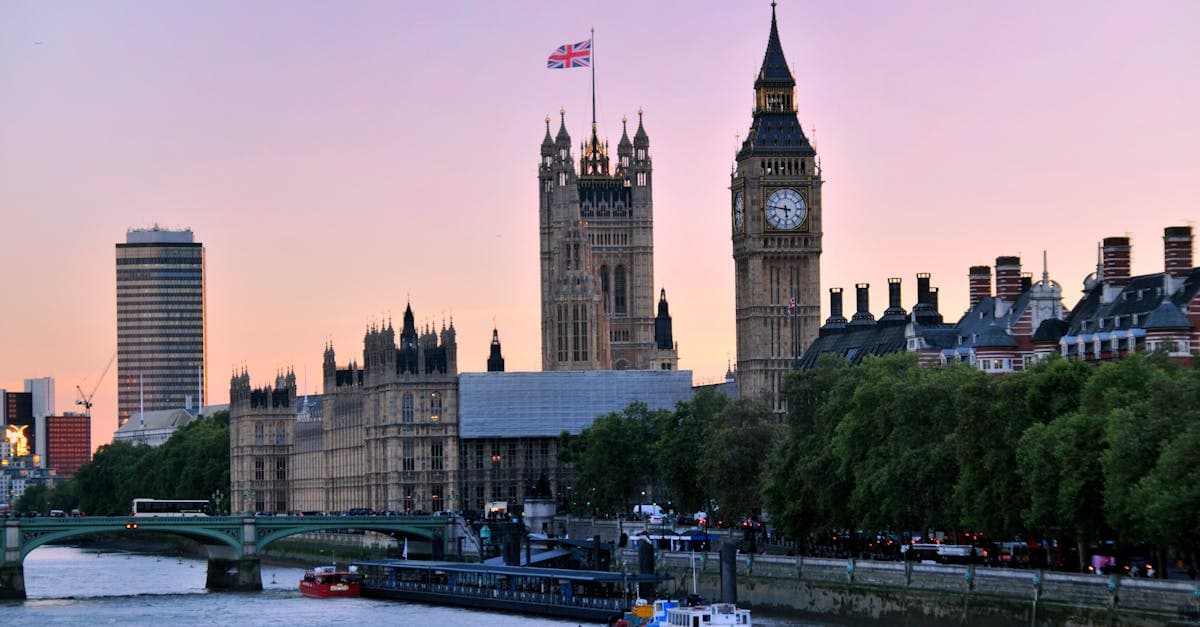 Big Ben e o Parlamento britânico ao pôr do sol junto ao rio Tamisa em Londres