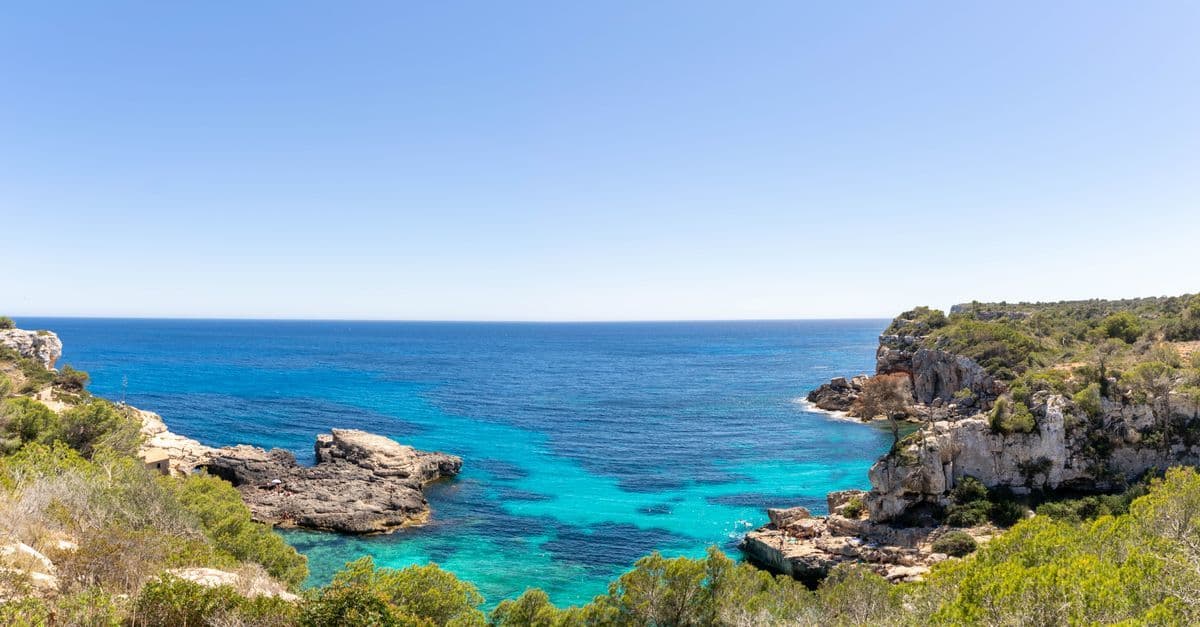 Sant Antoni de Portmany's dramatic cliffs and turquoise waters, near currency exchange spots in Ibiza