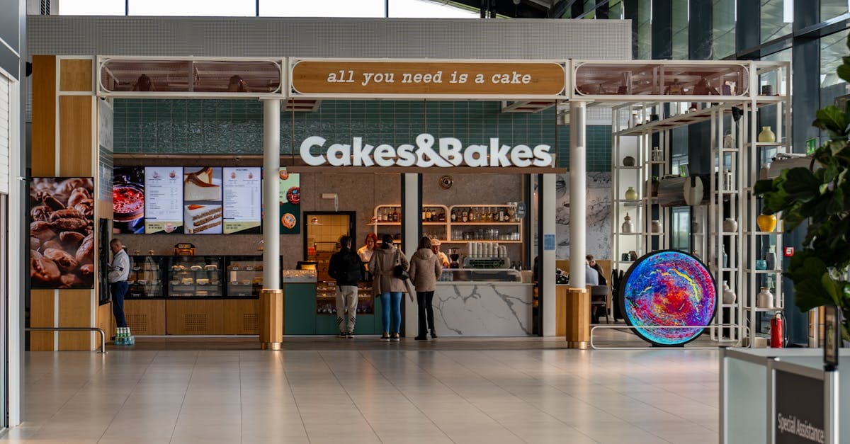 Café och bageributik inne i Alicante airports terminal med besökare och modern design.