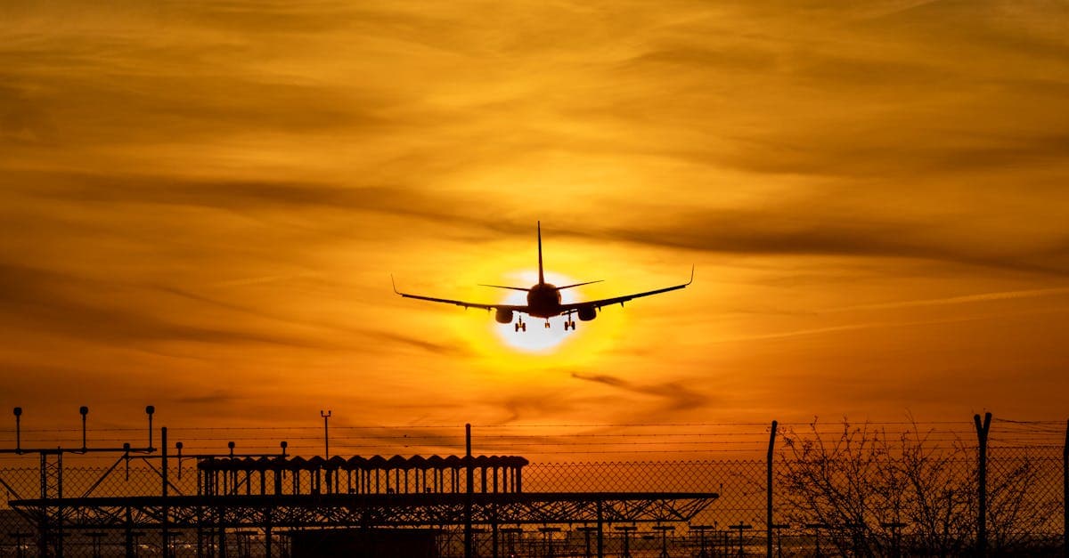 Silueta de avión aterrizando al atardecer en el aeropuerto de El Paso desde Ciudad Juárez