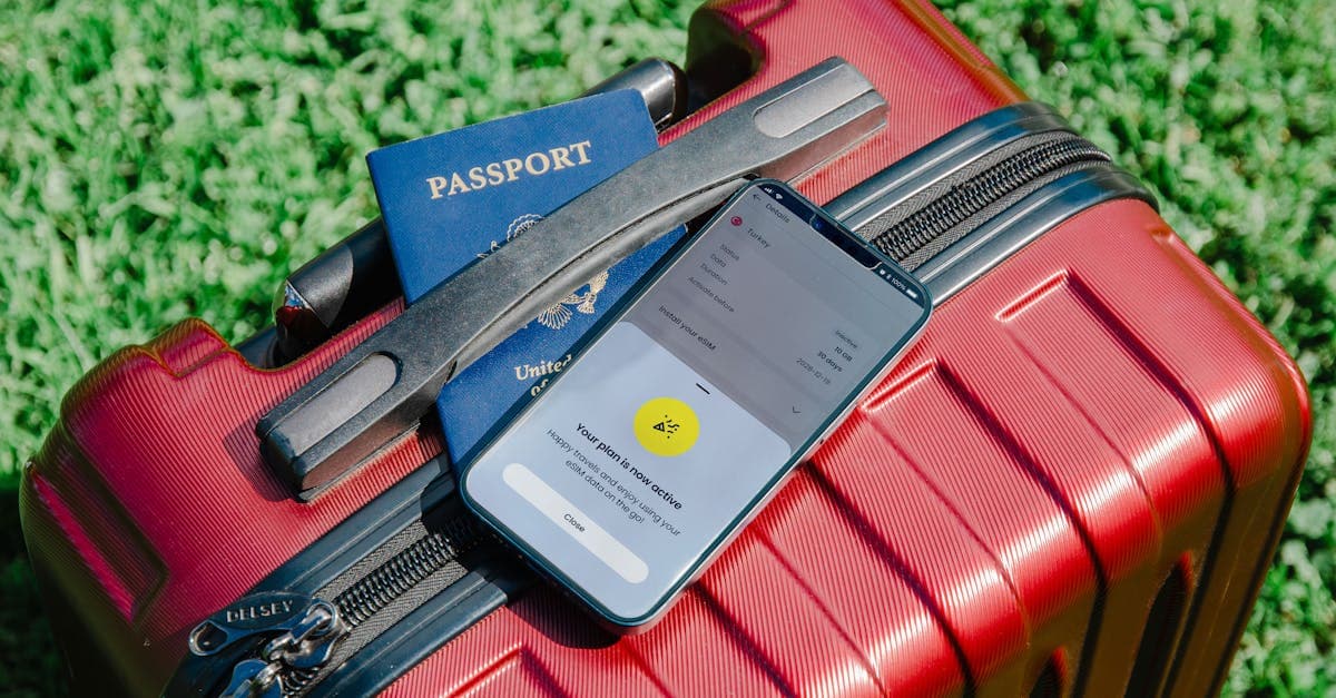 Close-up of a passport and smartphone on a red suitcase, perfect for travel themes.