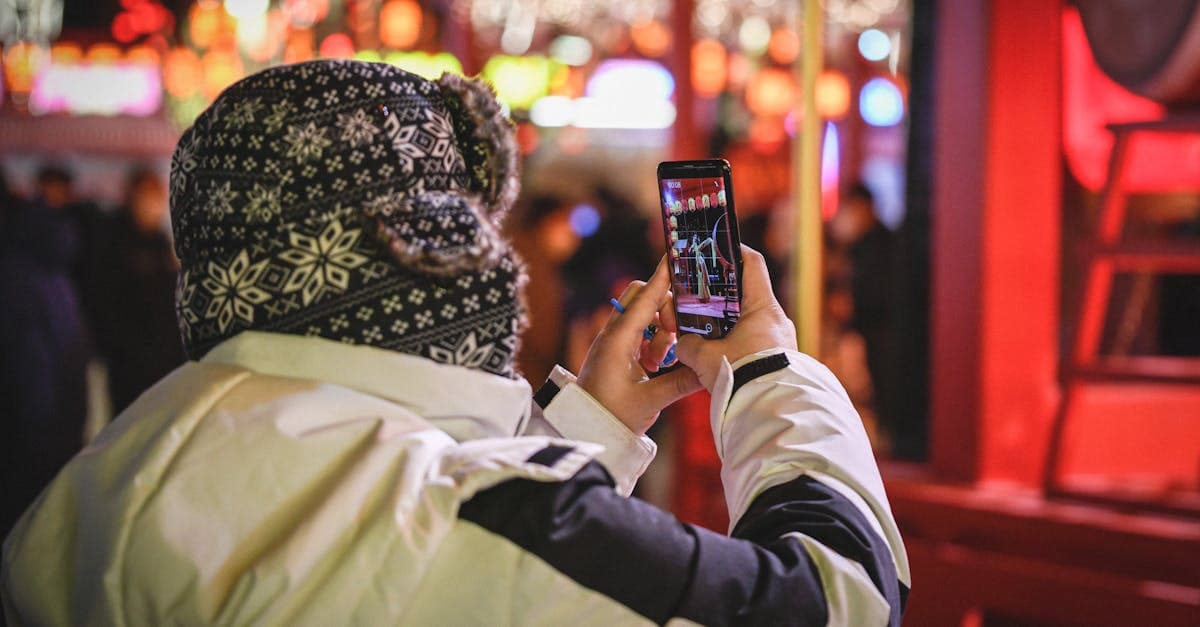 夜の屋台市場でスマートフォンを手にする旅行者、韓国での屋台めぐりに役立つ通信環境の整え方