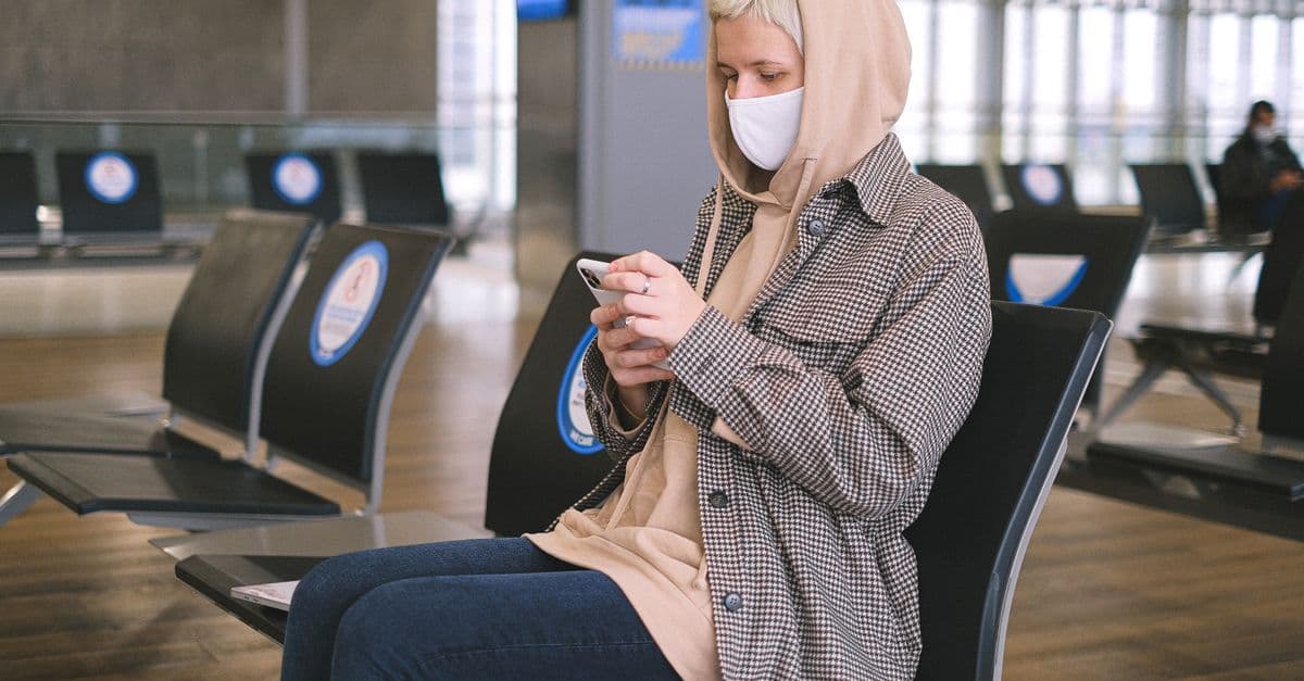 Frau nutzt am Flughafen ihr Mobilgerät – mit einer Schweizer eSIM bereits vor der Landung online.