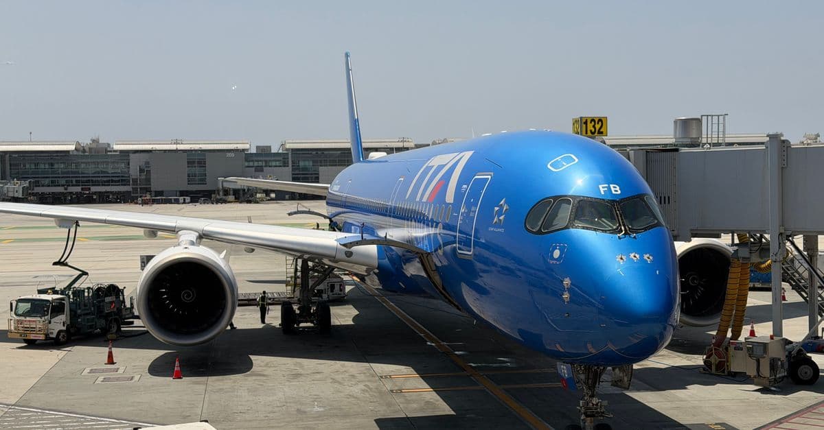 Avion commercial bleu garé à une porte d'embarquement pour vols internationaux vers les États-Unis à YVR