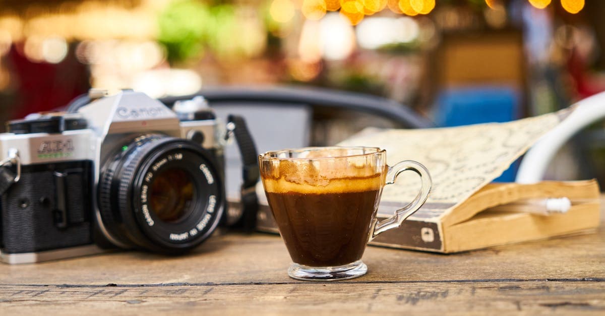 Taza de espresso y cámara vintage sobre mesa de madera, listos para viajar con cafe mega travel