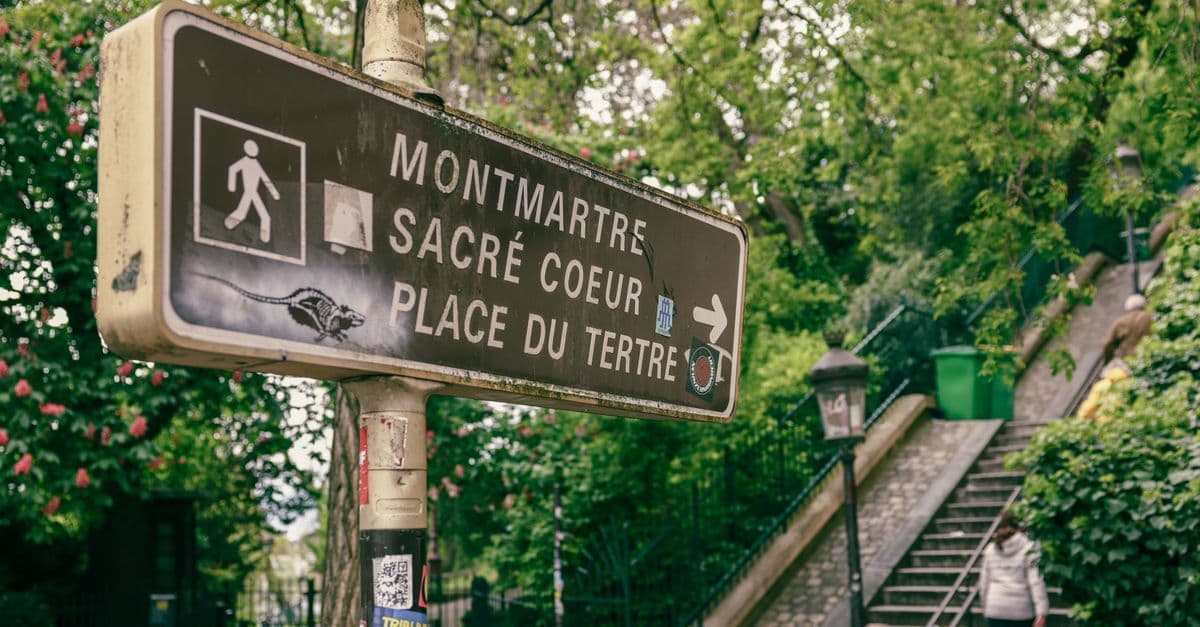 Cartello turistico a Montmartre con indicazioni per Sacré-Cœur e Place du Tertre, cosa vedere a Parigi lontano dai percorsi classici