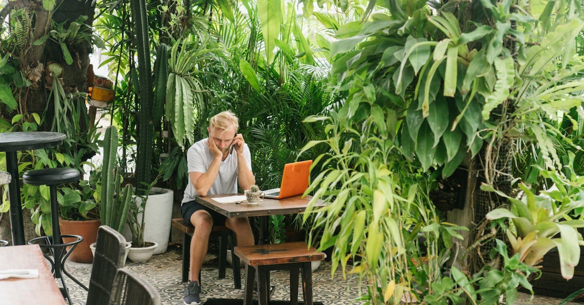 Man working remotely in a tranquil Bali garden cafe, perfect digital travel eSIM Bali coworking spot