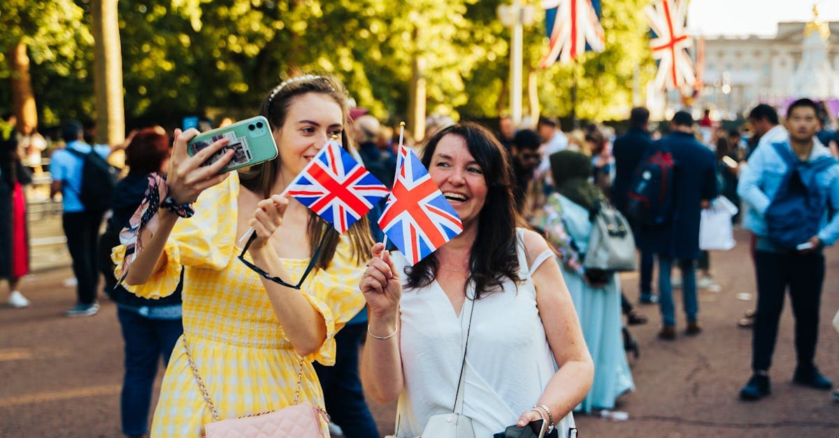 Two women celebrating in London with Union Jack flags, enjoying the best eSIM plans for UK travelers top picks 2026