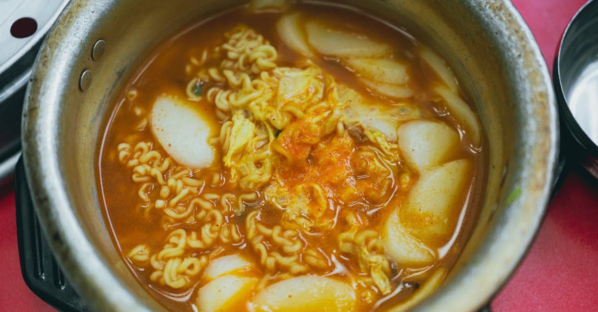Korean street food tteokbokki in spicy red broth with noodles and vegetables, ready to serve.