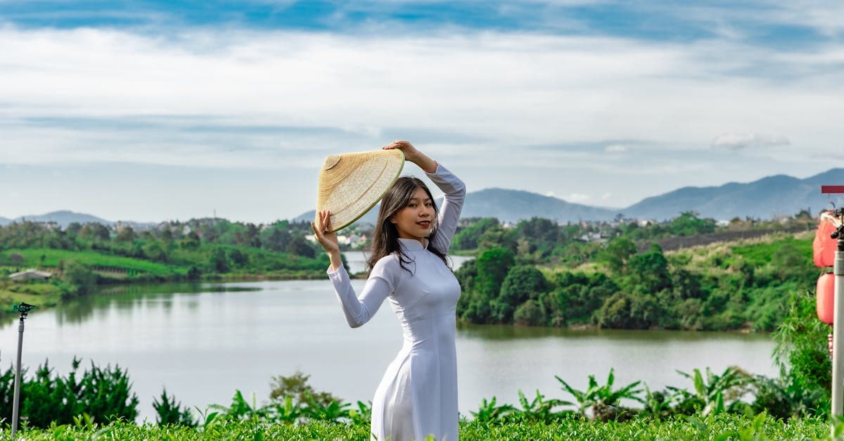 Phụ nữ Việt Nam mặc áo dài trắng đội nón lá bên hồ Bảo Lộc – bảo hiểm du lịch quốc tế 2026 cho người Việt đi nước ngoài