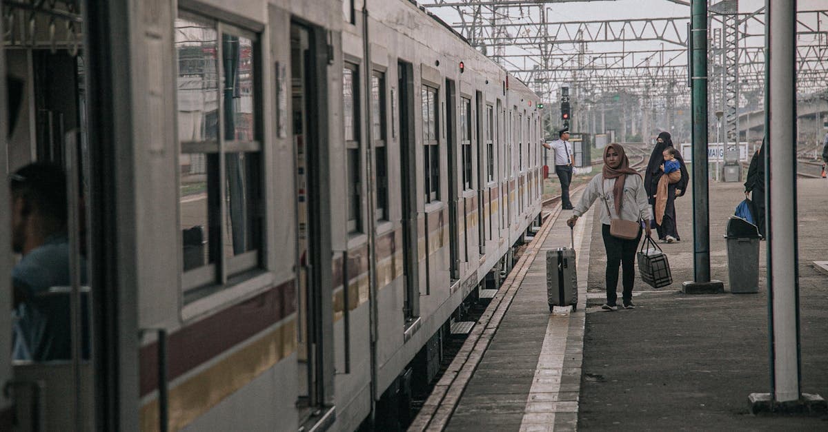 Para penumpang di peron stasiun kereta Jakarta bersiap melakukan perjalanan dengan klaim asuransi perjalanan yang mudah.