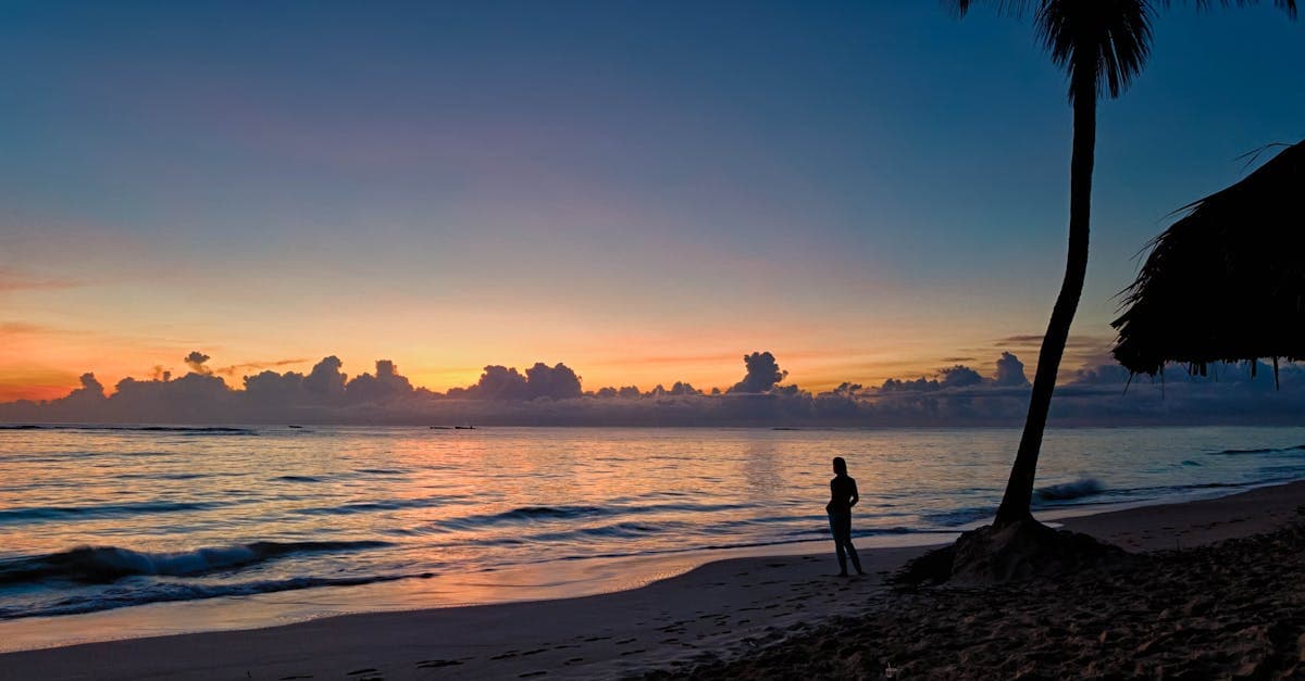 Femme en silhouette devant le coucher de soleil à Punta Cana, connectivité et eSIM de voyage en République dominicaine