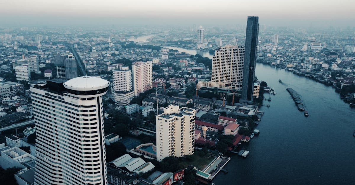 Flygvy över Bangkoks stadssiluett med Chao Phraya-floden och höghus i bakgrunden.