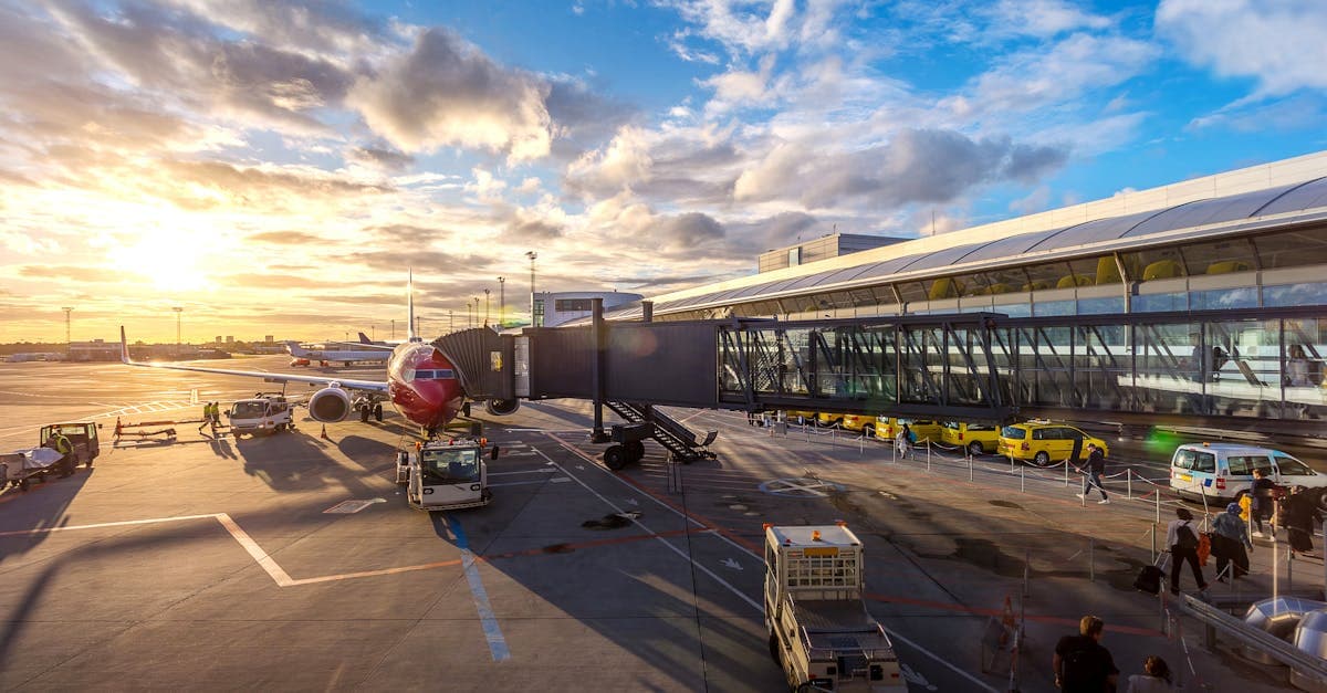 Solnedgång bakom flygplan på Alicante airport med livlig aktivitet på flygplatsen.