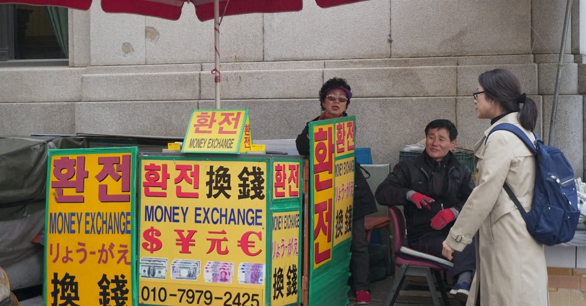 街中の両替所で話し合う二人の大人、韓国旅行に必要な現金の準備と持ち物のポイント