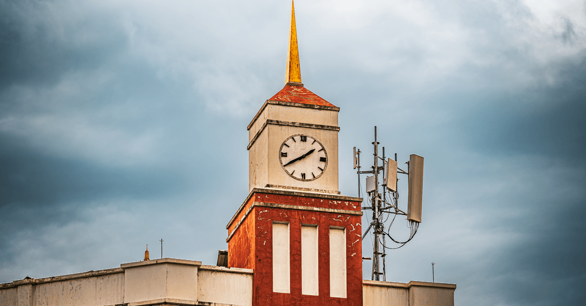 Bangkok clock tower against dramatic clouds, representing the importance of knowing the current time in Thai language.