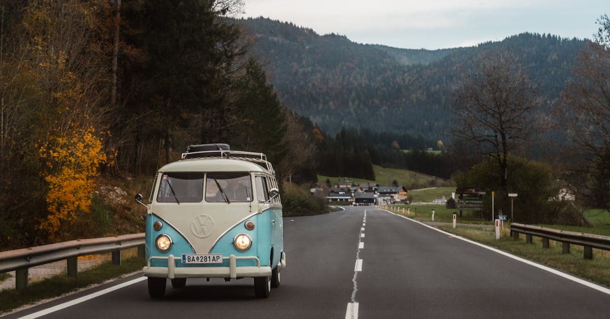 Furgone vintage percorre una strada pittoresca tra i colori autunnali, perfetto per ispirare un road trip in Italia