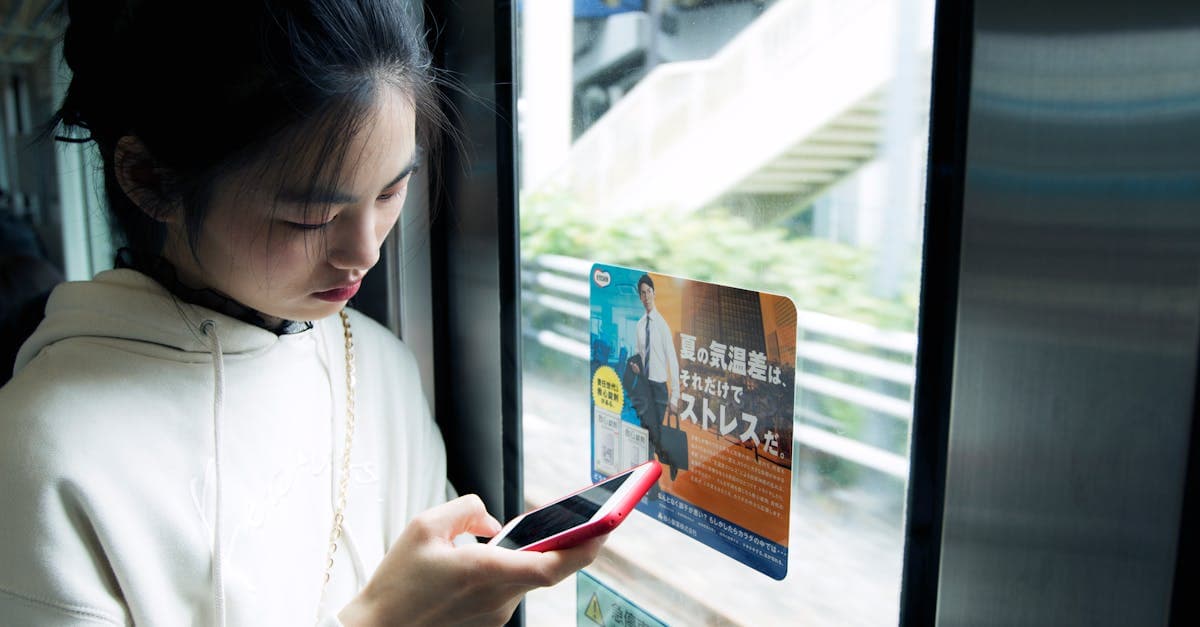 Jovem viajante conectada ao smartphone a bordo de trem japonês, mantendo-se online durante a viagem