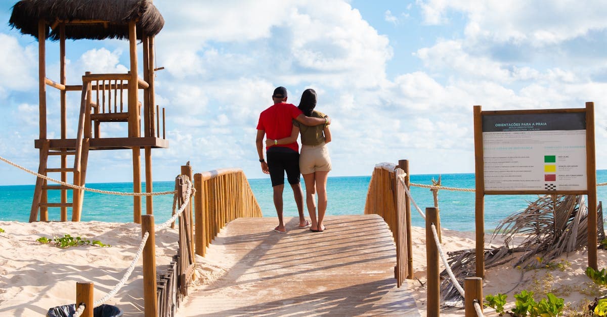 Pareja tomada de la mano caminando hacia la playa en Brasil, confiando en el Unlimited Vacation Club.