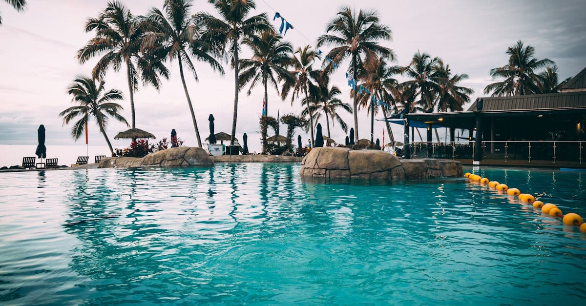 Luxurious Fiji resort pool lined with palm trees, ideal for hand-crafted fiji holiday packages and island escapes