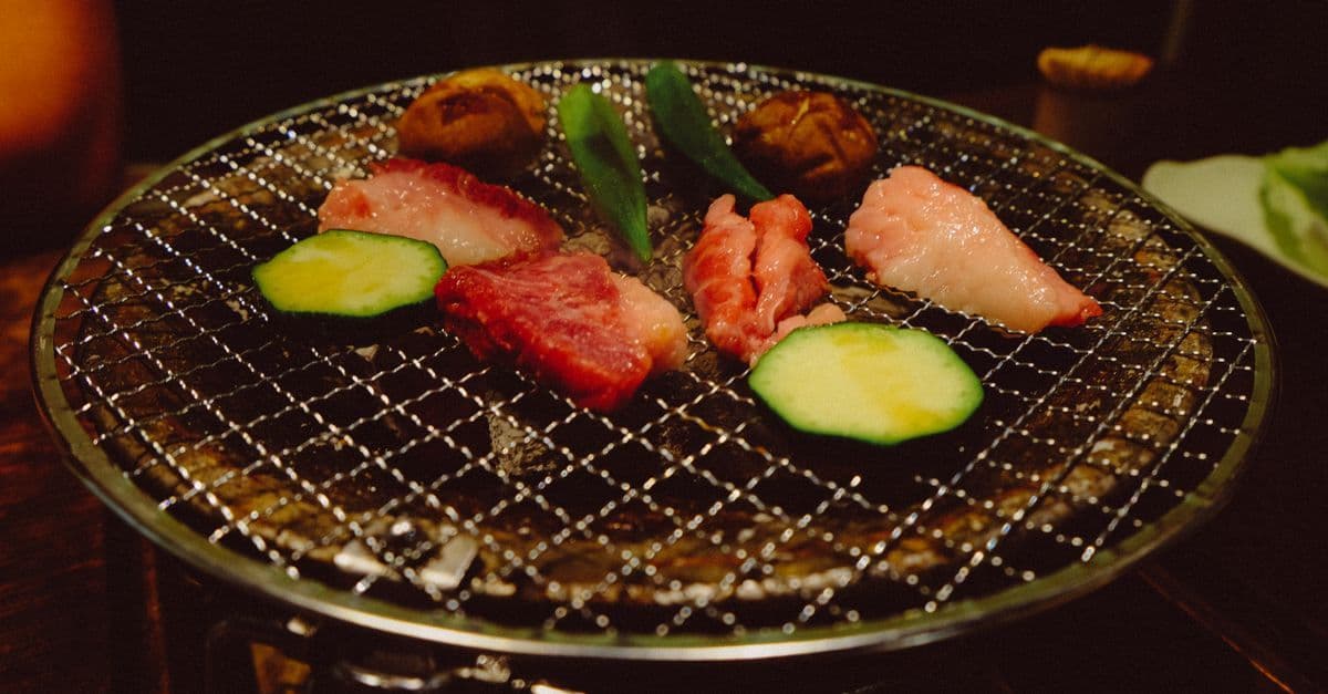 台灣一人燒肉店室內炭烤爐上,鮮嫩肉片與時蔬滋滋作響令人食指大動