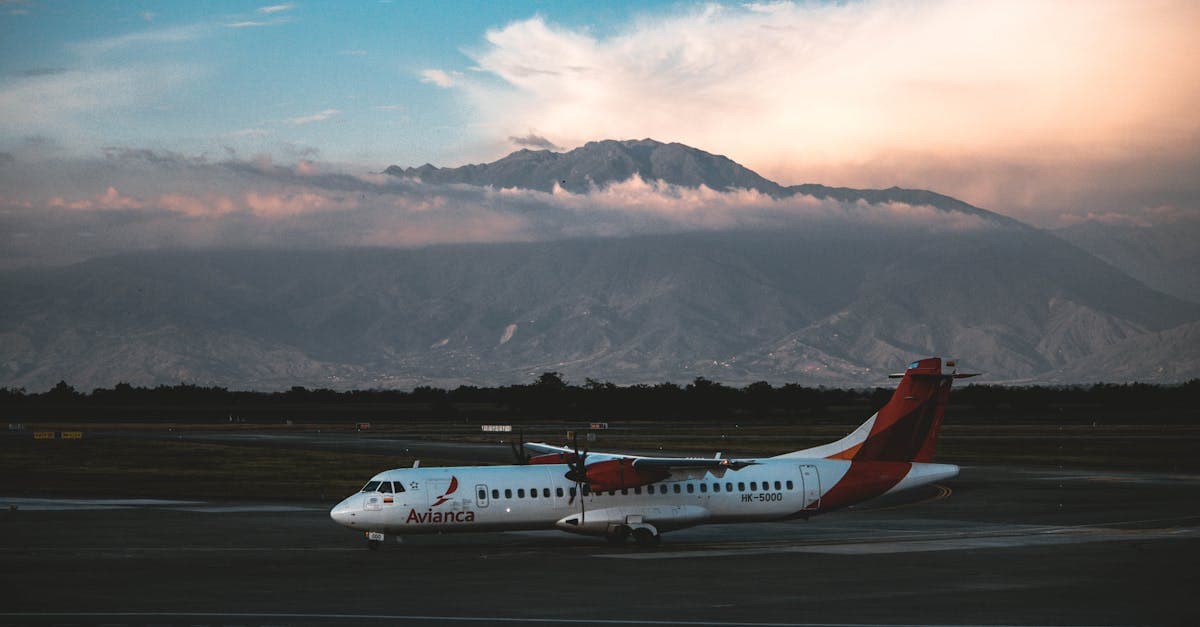 Aeronave estacionada en la pista con majestuosas montañas colombianas al fondo, referencia visual de vuelos a Colombia