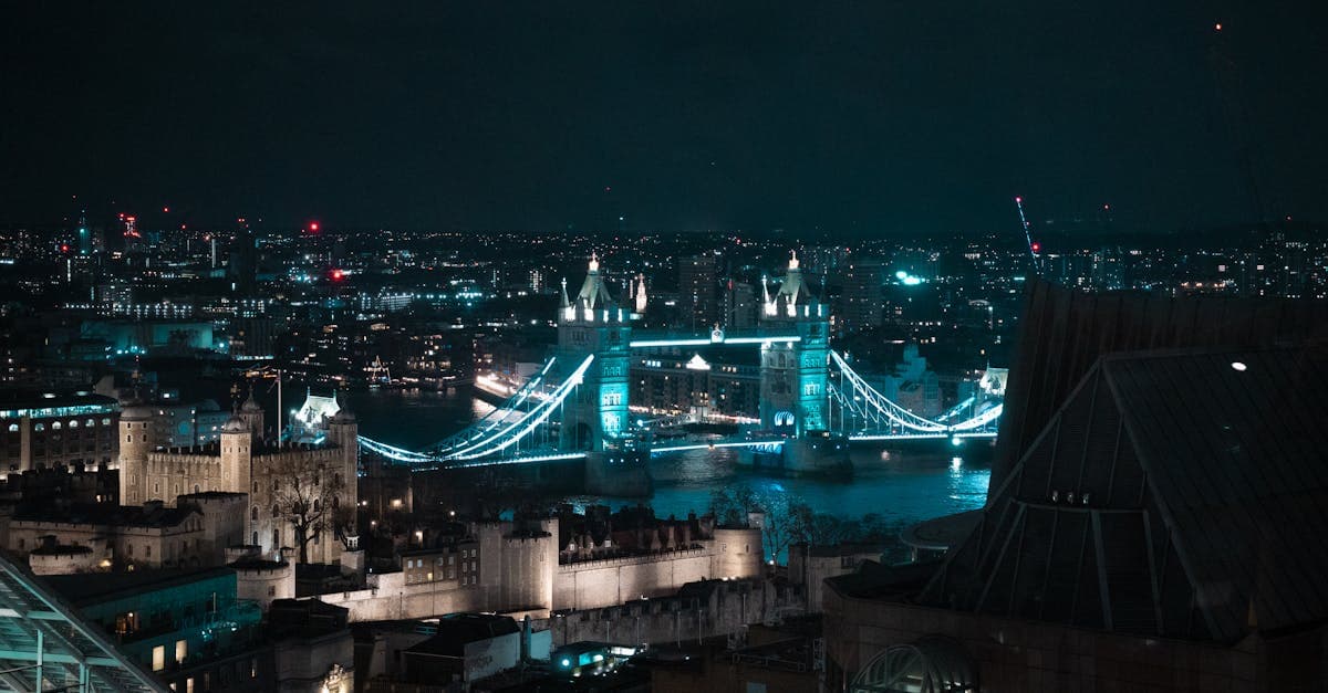 Tower Bridge de Londres iluminado por la noche reflejándose en el Támesis en Navidad.