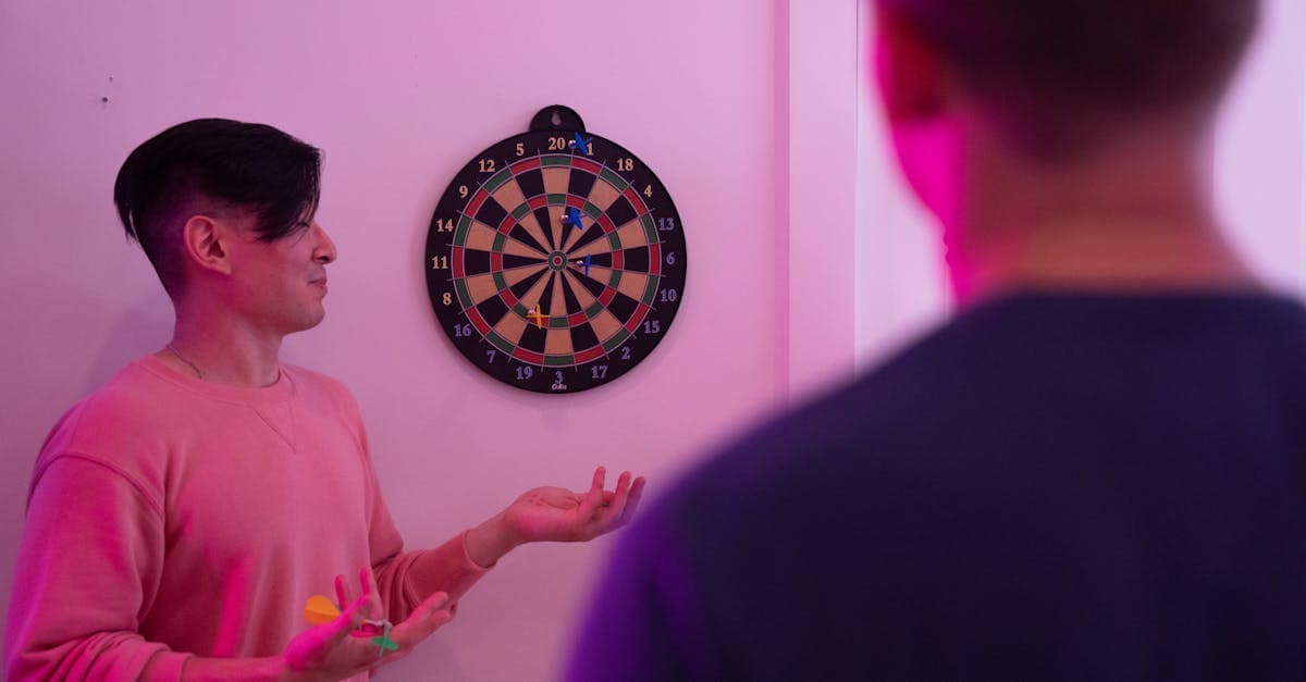 Zwei junge Männer spielen Darts in pinkem Licht – Ticket-Verkaufsstart für die Dart WM 2026