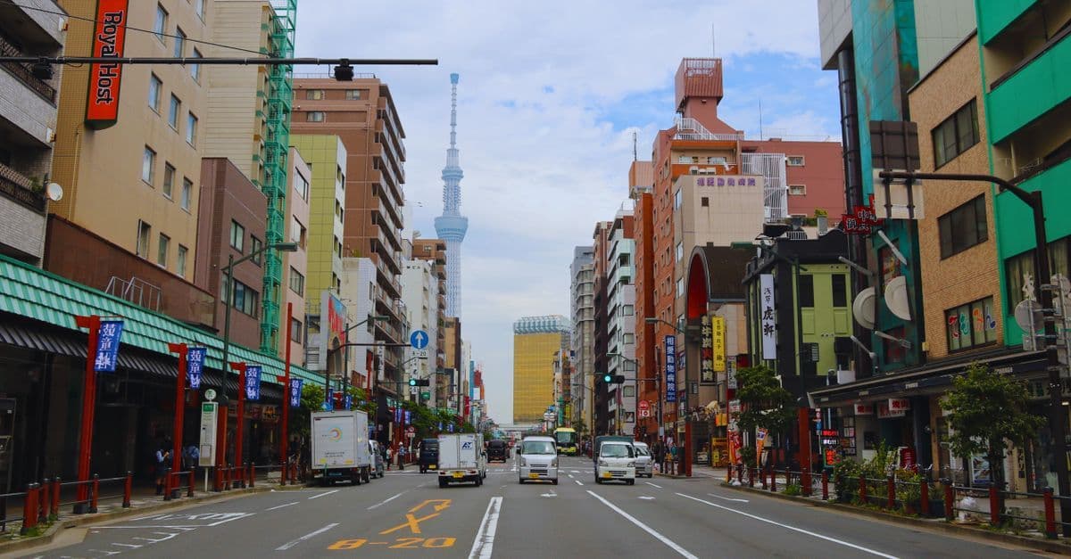Busy Tokyo street with Tokyo Skytree rising prominently above the urban neighbourhood.