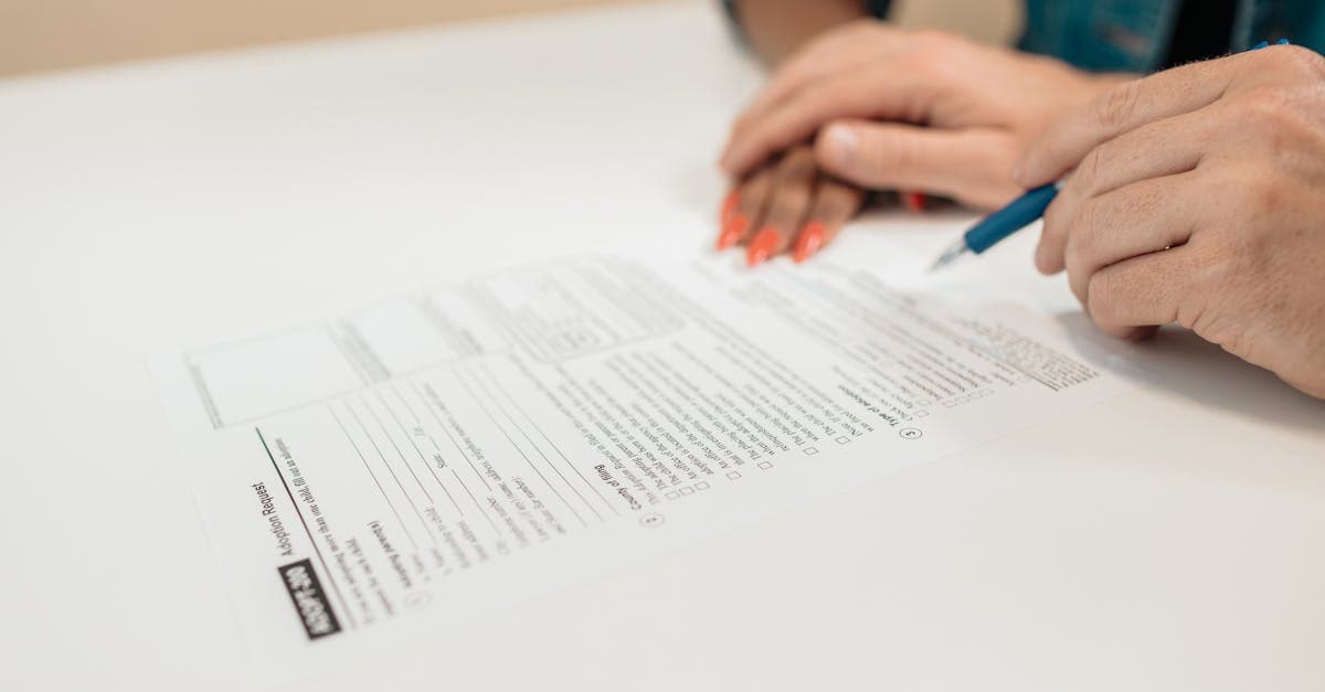 Hands signing official documents in an office, representing digital travel eSIM visa spain eligibility requirements