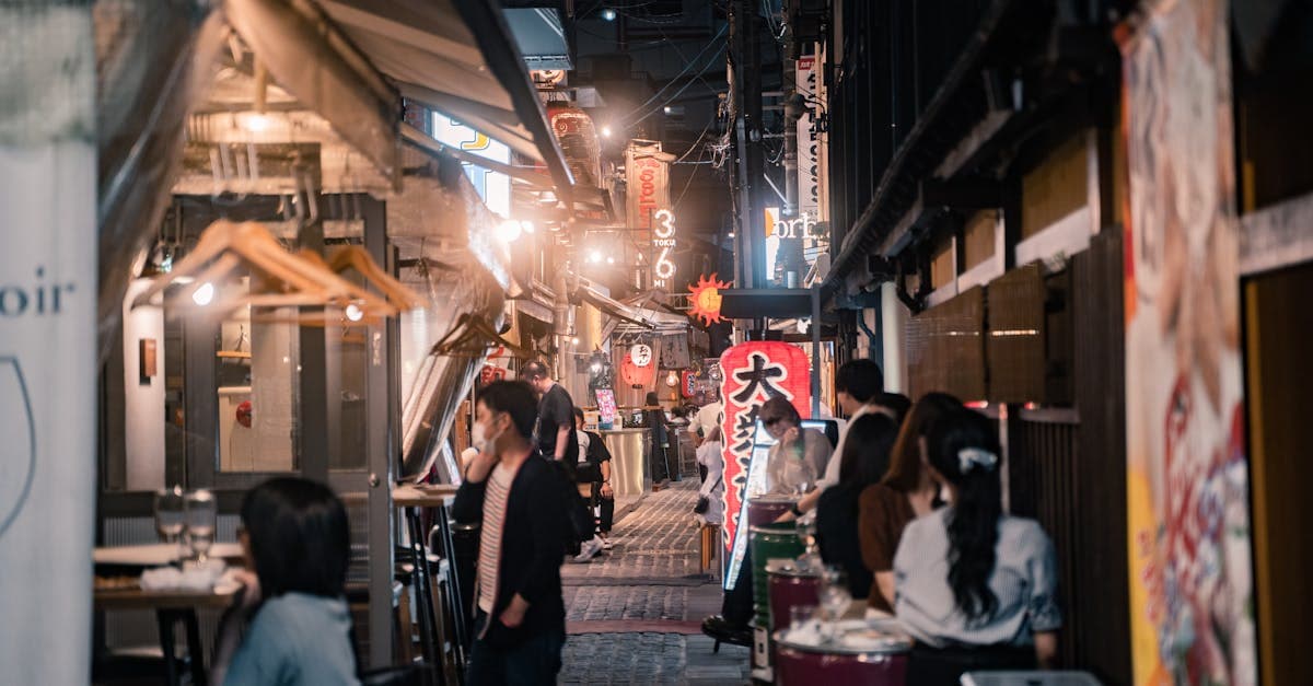 Crowded Osaka dining alleyway lined with izakayas and street food stalls to explore after dark