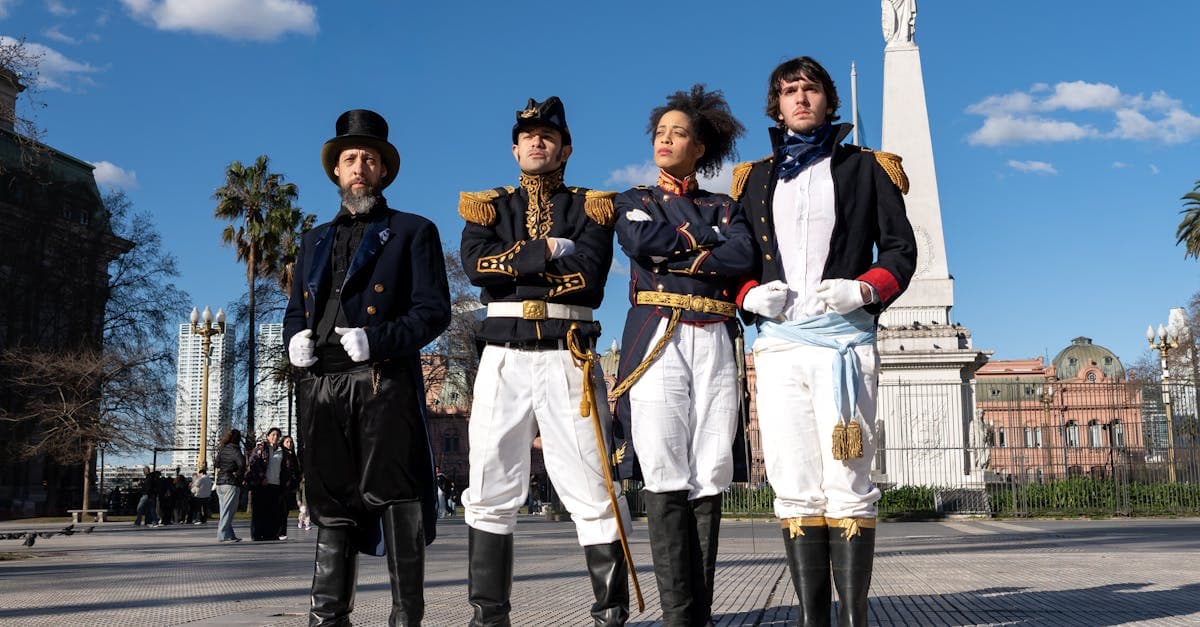 Atores em trajes históricos posam ao lado do Obelisco de Buenos Aires sob um céu azul nítido