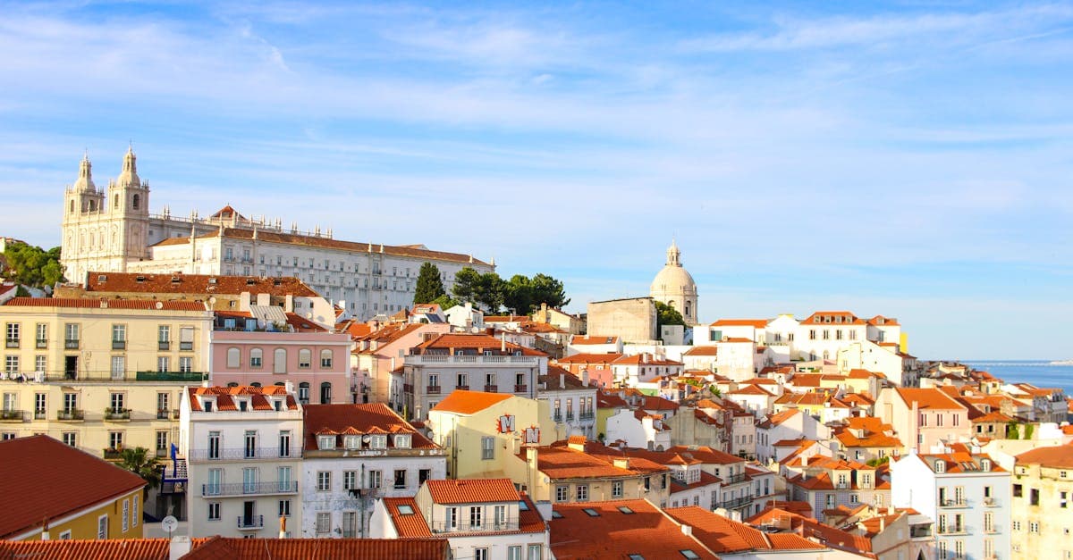 Que faire à Lisbonne : vue panoramique sur le quartier historique d'Alfama sous un ciel dégagé.