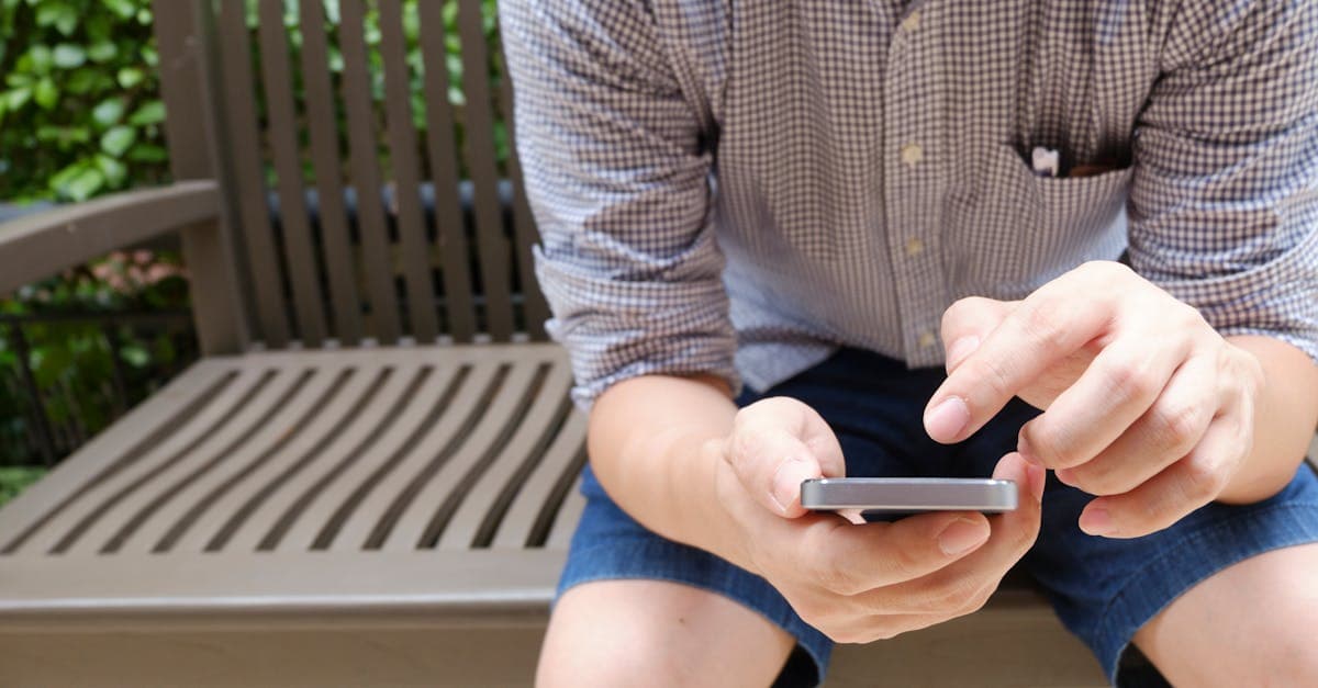 Man browsing smartphone outdoors, comparing portable wifi hotspot options for travel