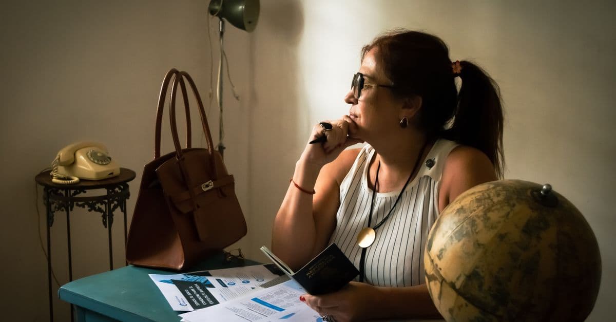 Woman reviewing travel documents and paperwork required to renew a UK passport online successfully