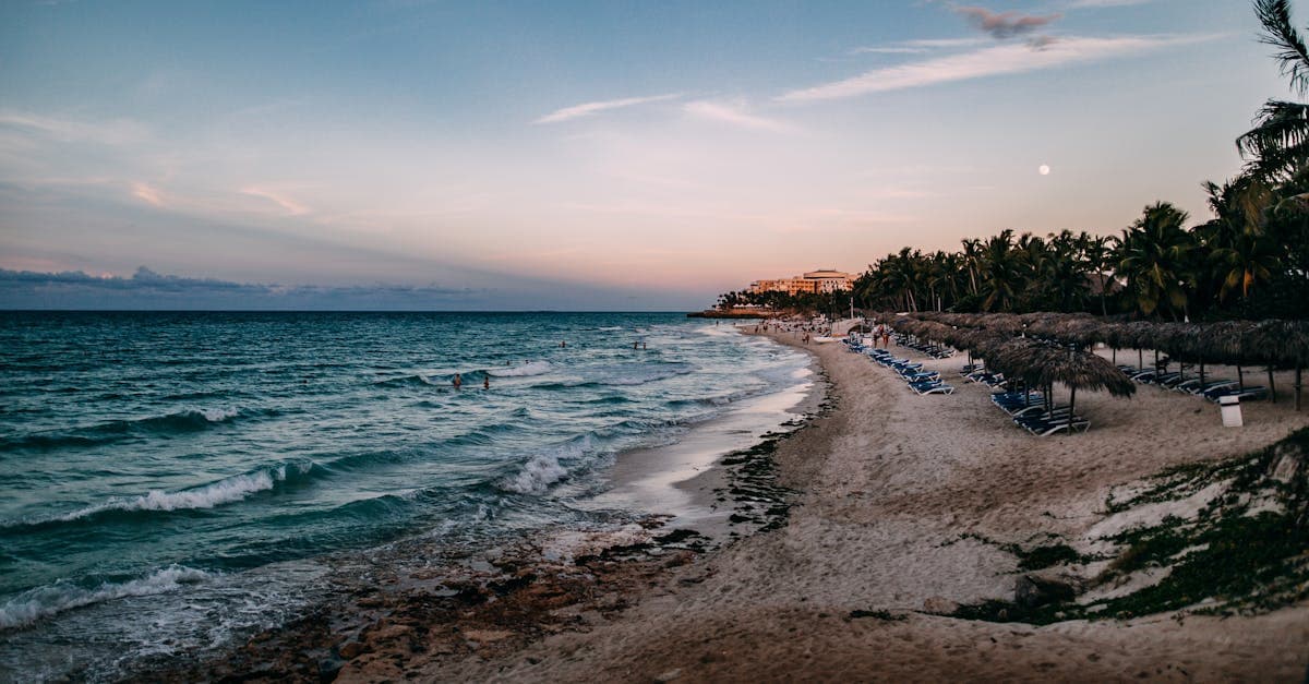 Plage de Varadero au coucher du soleil avec palmiers et vagues calmes, destination phare des cheap trips to cuba