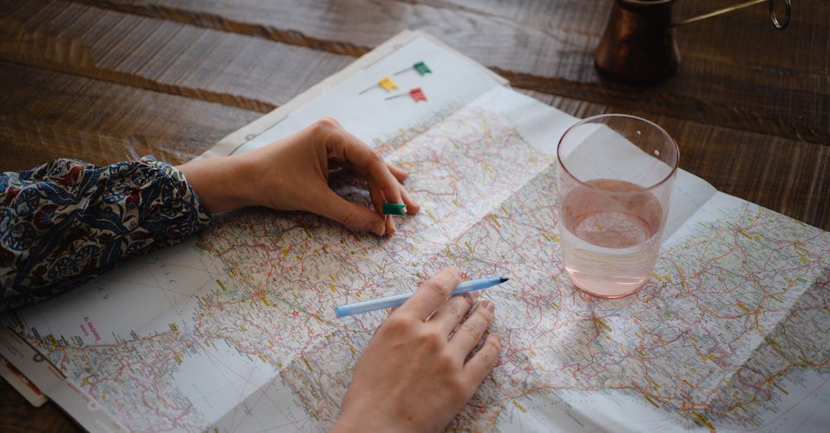 Woman placing a pin on a map while planning a trip to decide which region of India to explore.