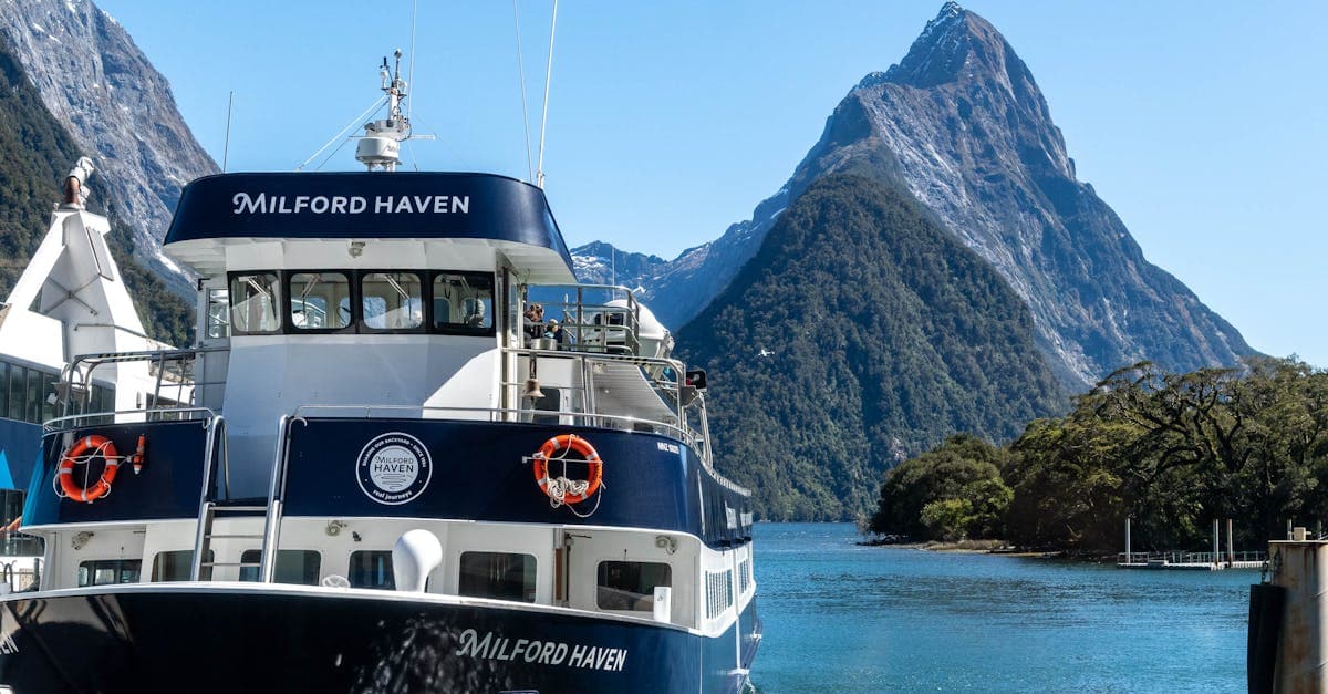 Cruise ship sailing through Milford Sound's towering mountains and clear blue water, a stunning South Island port of call.