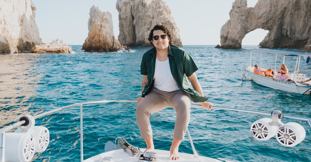 Hombre sonriente en un bote frente al Arco de Cabo San Lucas, símbolo del turismo mexicano.