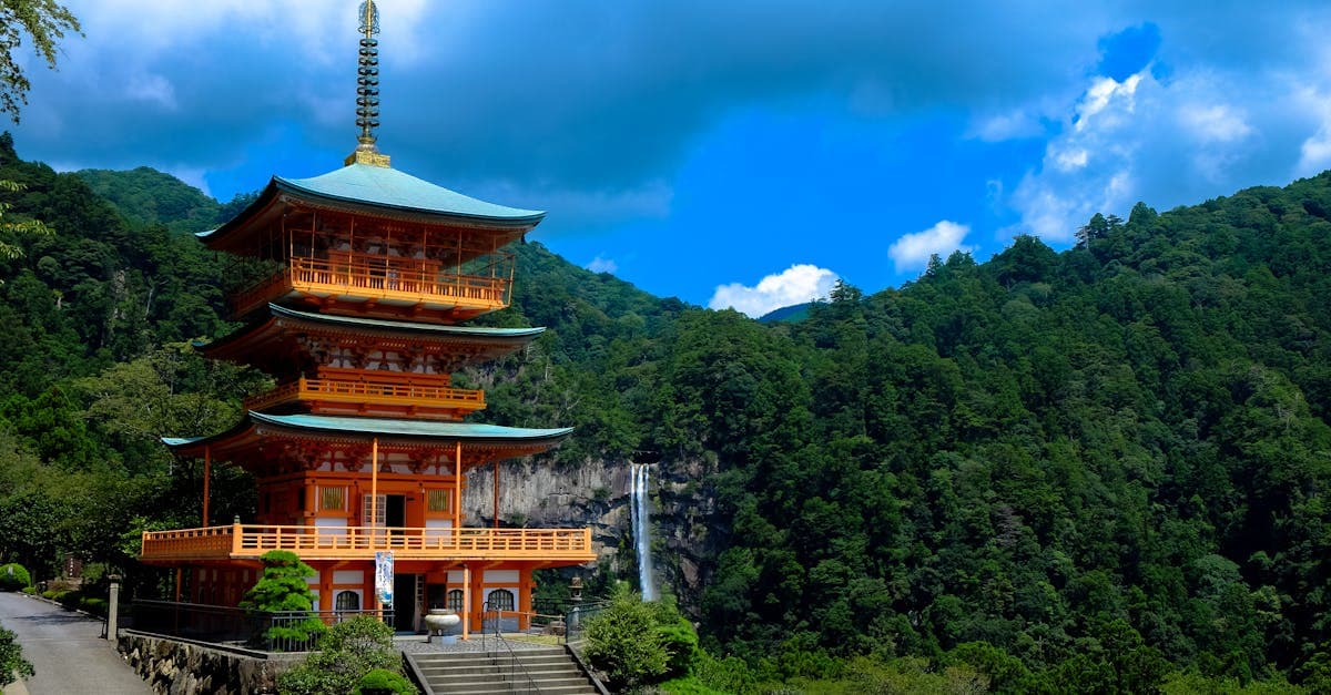Kumano Nachi Taisha pagoda rising above lush green mountains beside Japan's tallest waterfall, Nachi Falls