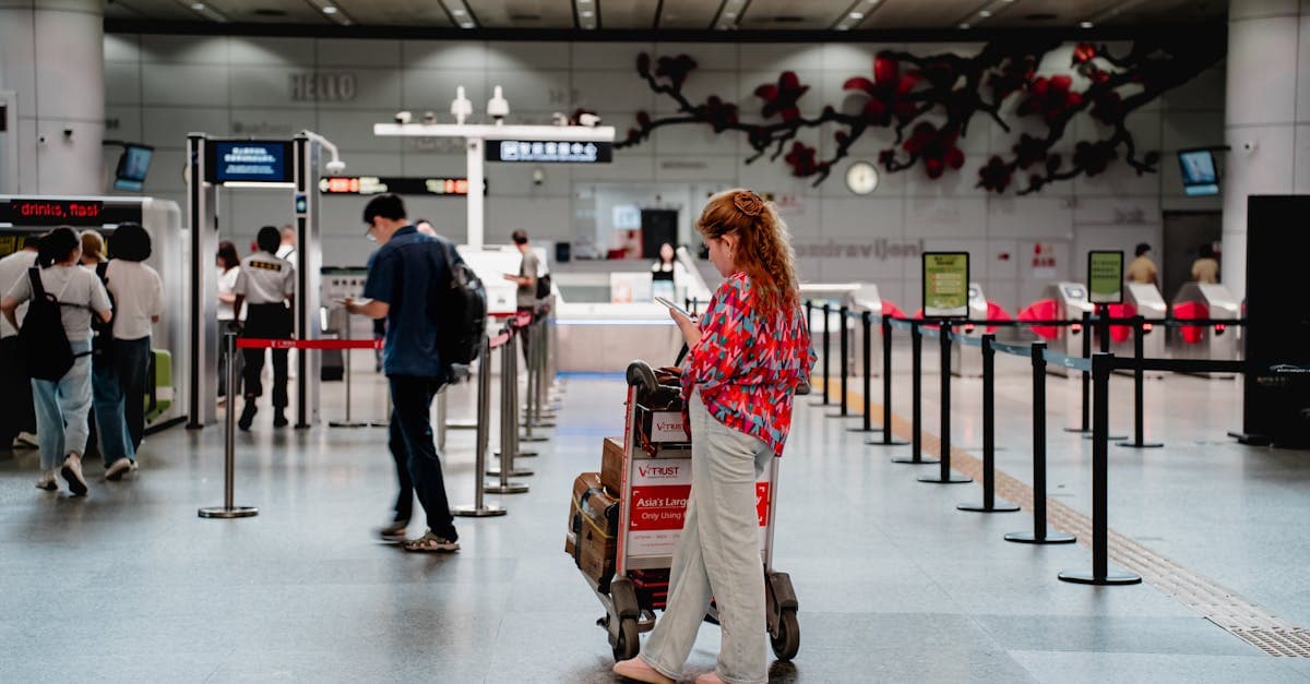 Traveler checking her phone at a busy airport terminal while preparing for her European trip